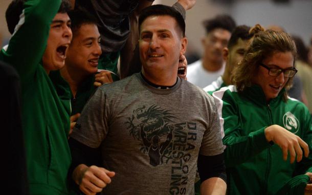 Kubasaki coach Brent Cook and his Dragons wrestlers celebrate their repeat Far East Division I individual freestyle team title. The Dragons would go on to sweep both D-I team titles, individual freestyle and dual meet, giving Cook three Far East wrestling banners in his four years of coaching.