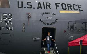 A young man steps out of a C-17 Globemaster II onto stairs. Above the doorway, lettering reads “U.S. Air Force” and “Spirit of Kamehameha.”