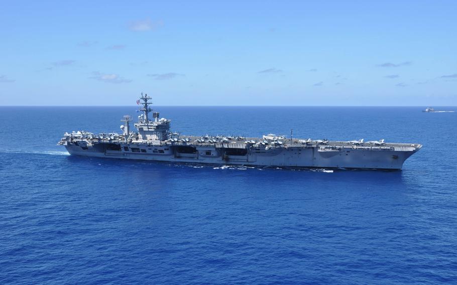 A sideview of an aircraft carrier at sea.