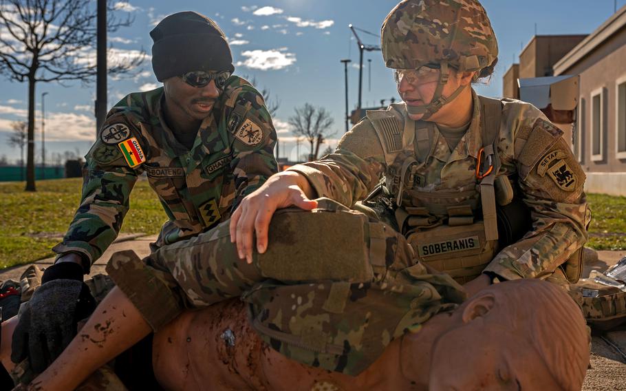 A U.S. soldier and a soldier from Ghana assess a simulated casualty during an exercise.