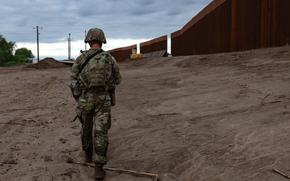 A National Guard soldier patrols along the wall at the southern border.
