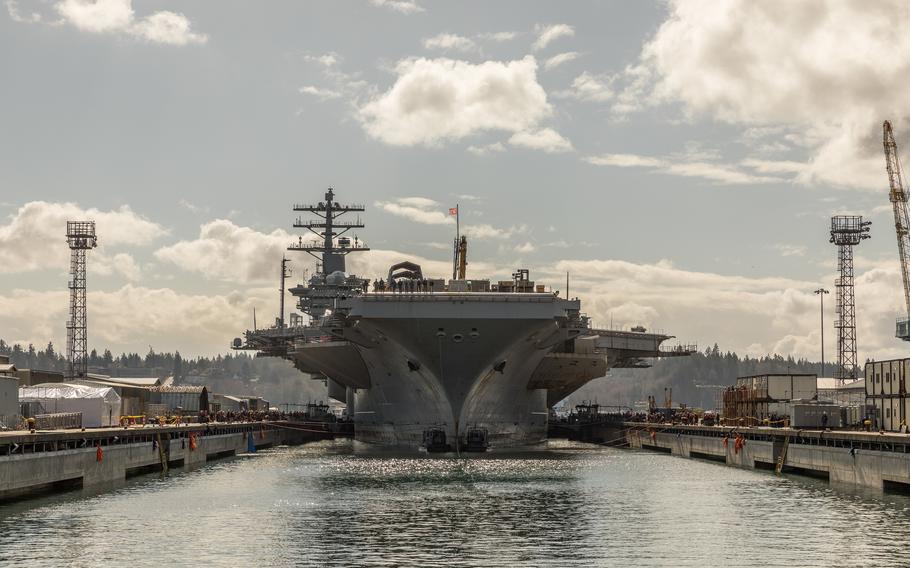 An aircraft carrier seen from the front of the ship in dry dock.